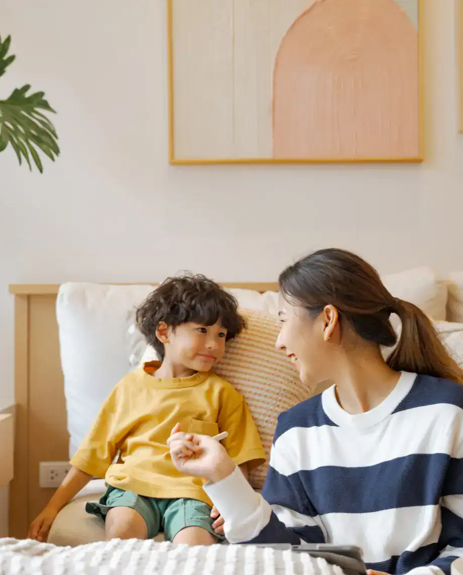 Happy mother and child sharing a joyful moment on the sofa in a stylish, well-lit living space.
