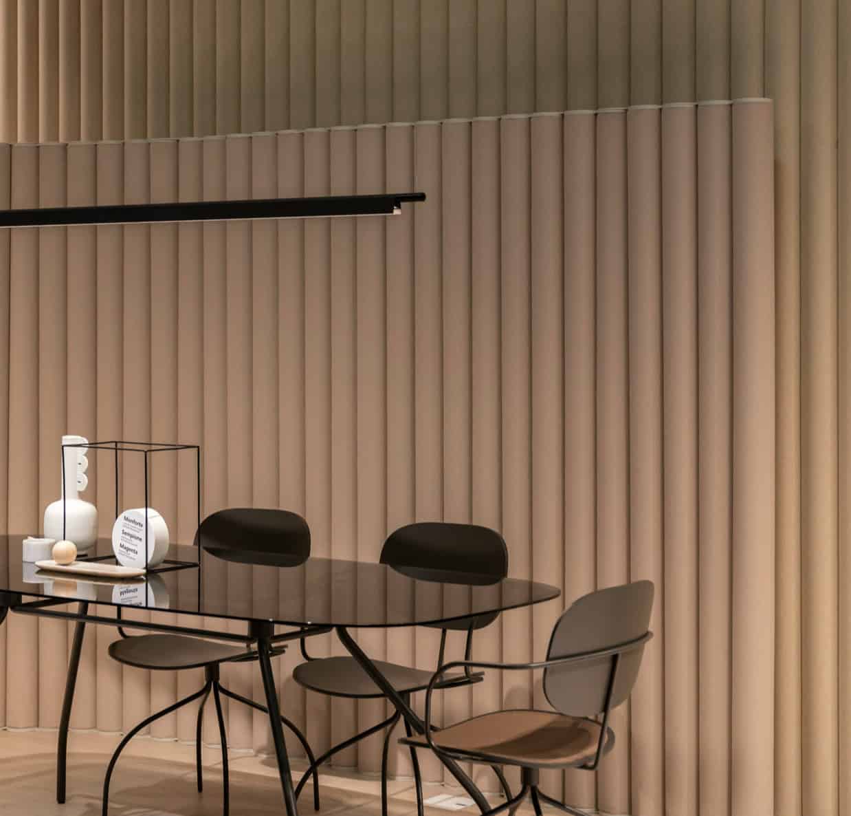 Contemporary dining area featuring sleek black chairs and a round glass table.