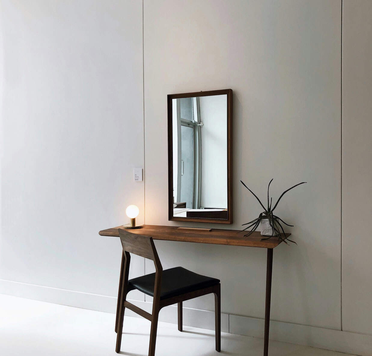 Elegant wooden desk with mirror and ambient lighting for stylish home decor.