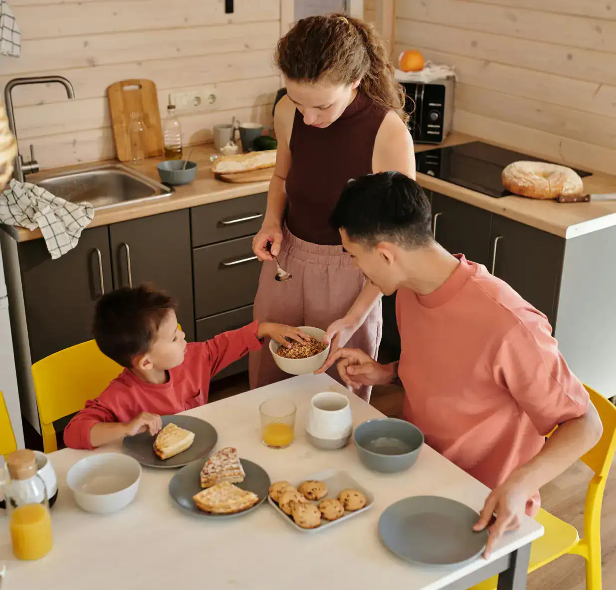 Family enjoying breakfast in a contemporary kitchen setting.