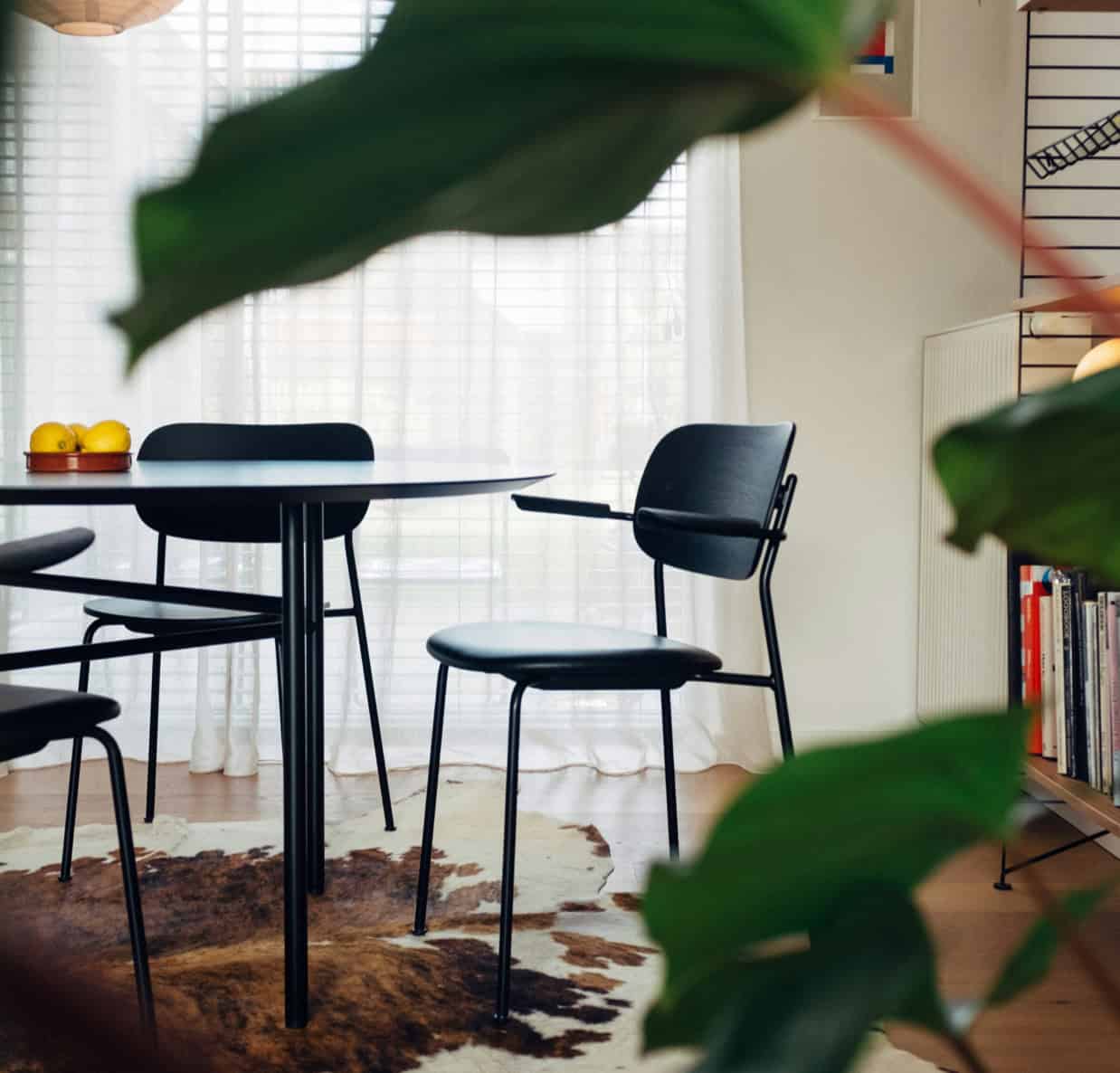 Black dining chairs and table in a bright, modern kitchen setting.