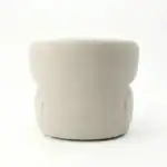 Armchair with soft beige upholstery and rounded design.