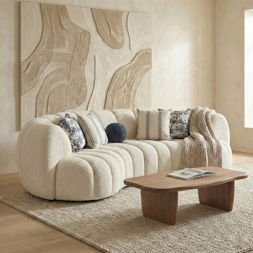 Comfortable Morella sofa with soft fabric and decorative cushions in a cozy living space.
