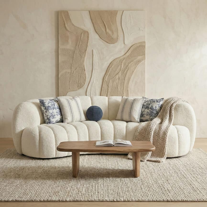 Elegant plush sofa with decorative pillows in a stylish living room setting.