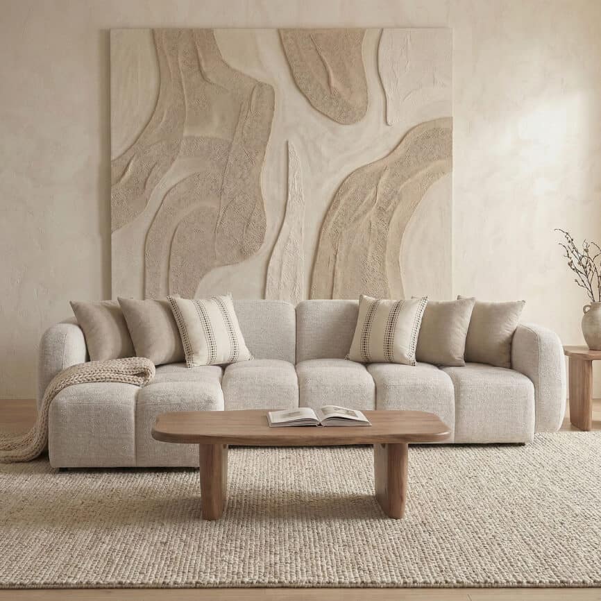Elegant beige sofa with decorative pillows in a contemporary living room setting.